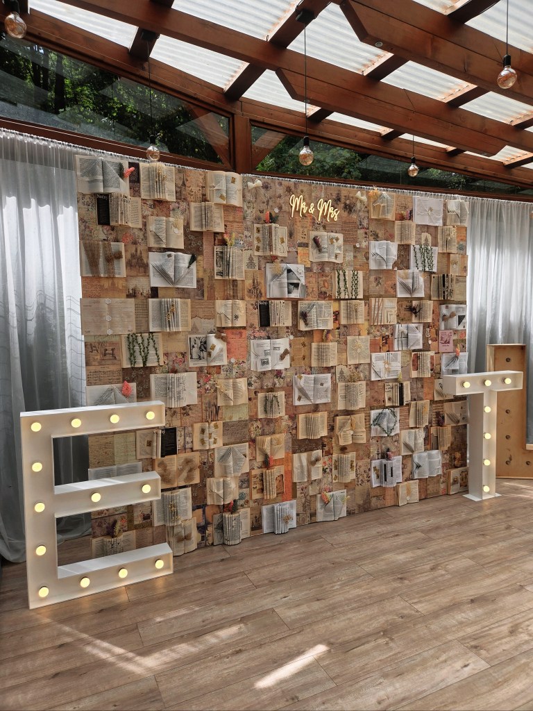 Knižná fotostena The story wall s LED iniciálmi E a T na svadbe v Chate Hrádok, Kamenec pod Vtáčnikom.